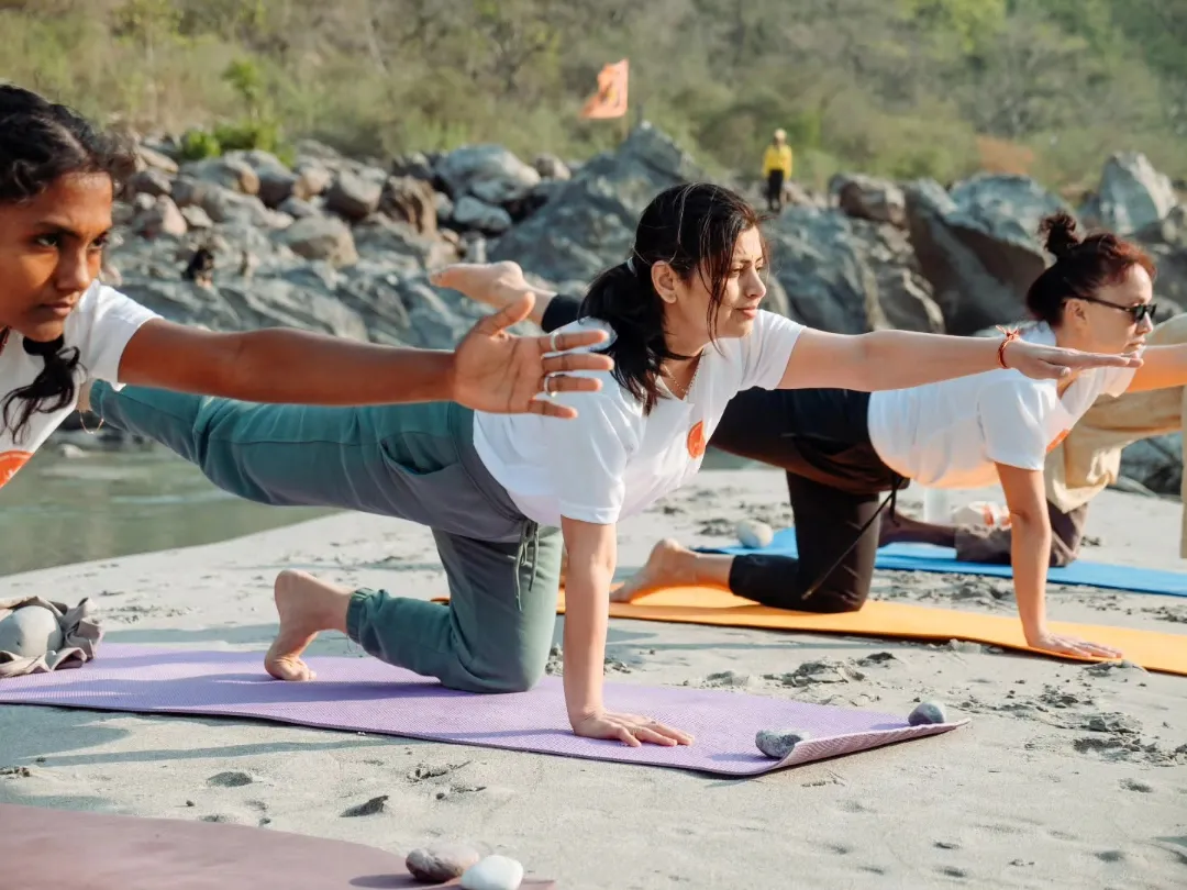 Teacher guiding a student through an aerial inversion in a small group class