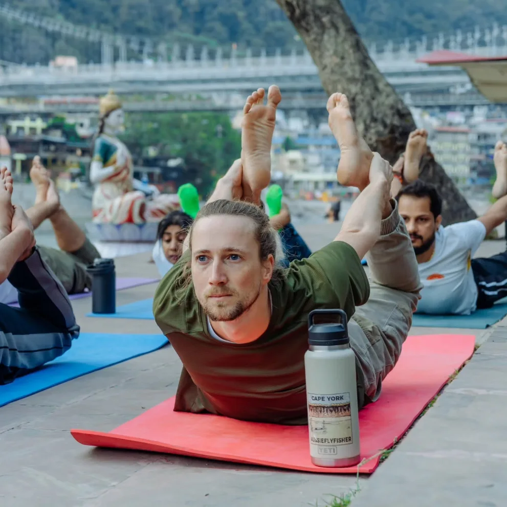 Small group practising locust pose on the ghats in Rishikesh