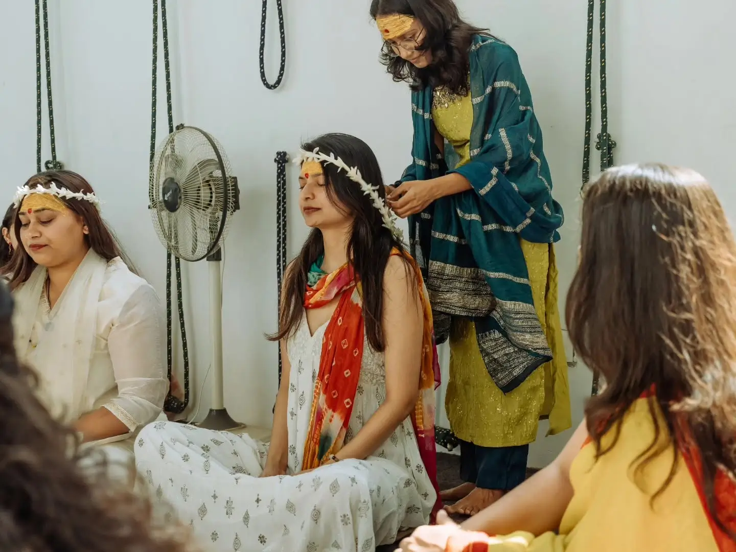 Students receiving flower crowns during a ceremony at Rishikesh Yog Kendra