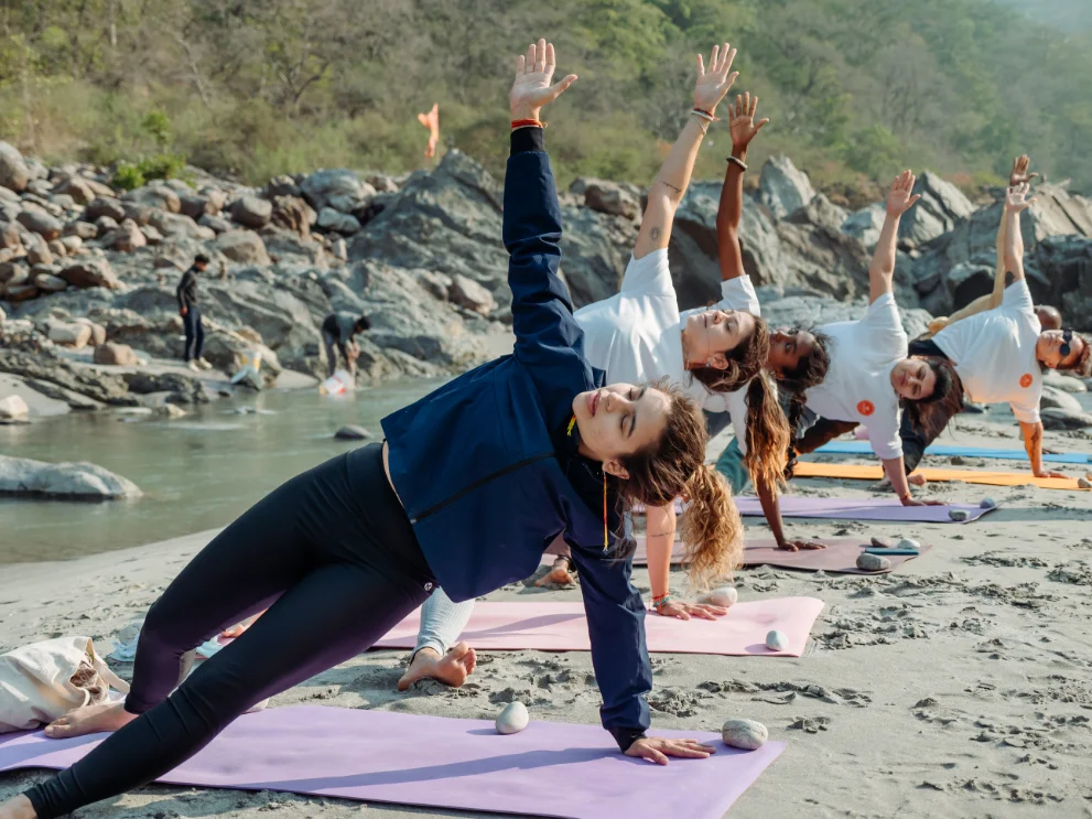 300 Hour Yoga Teacher Training students holding side plank beside the Ganga in Rishikesh