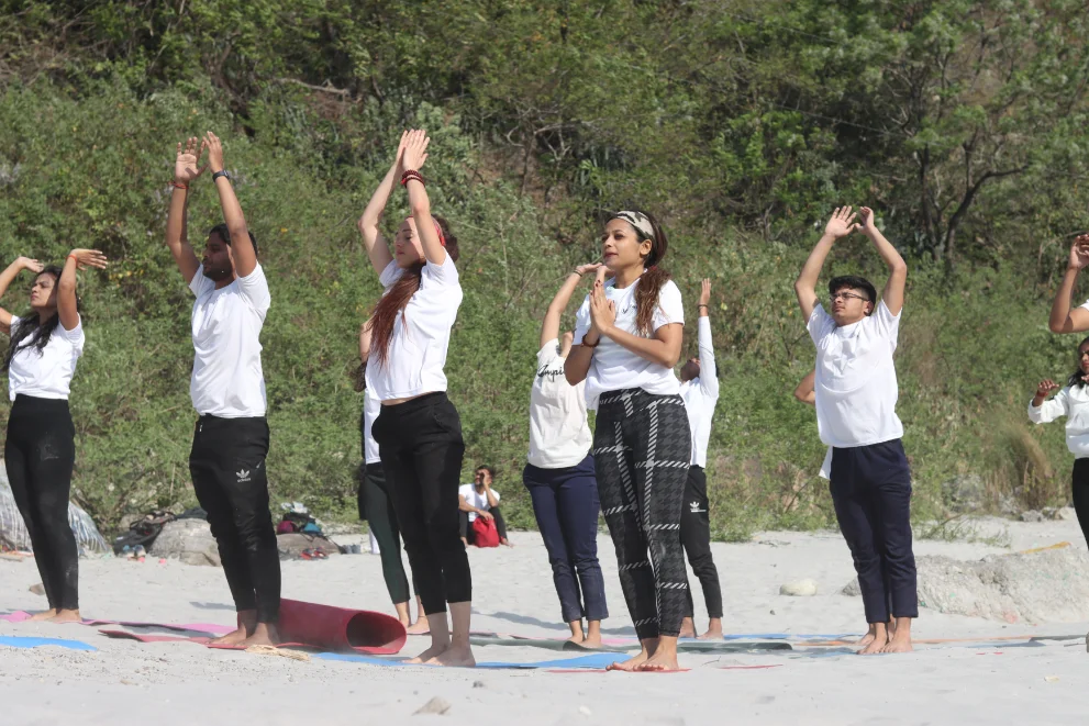 Students standing in prayer position at the start of a sun salutation