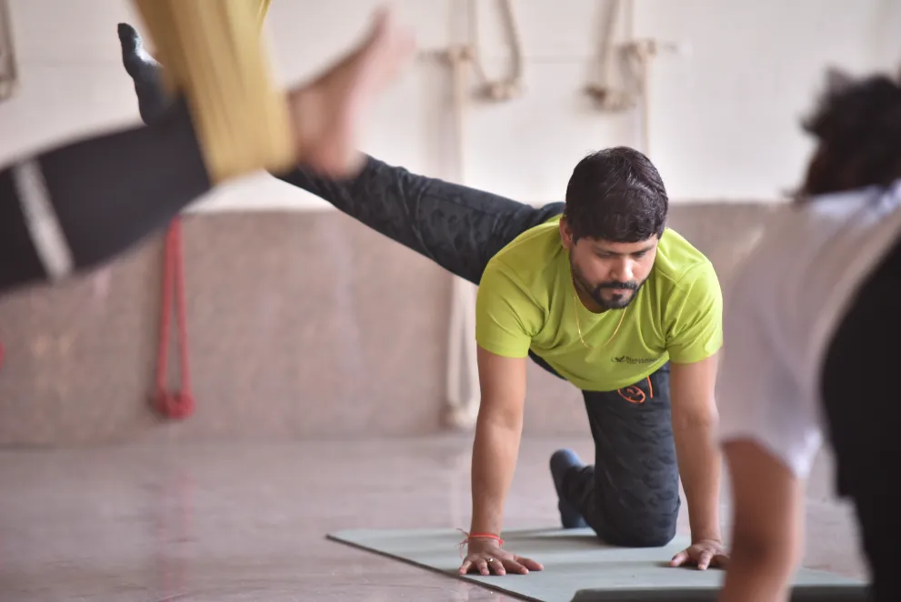 Instructor demonstrating a posture on the mat while the class follows