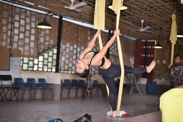 Student working a supported backbend in the aerial silk
