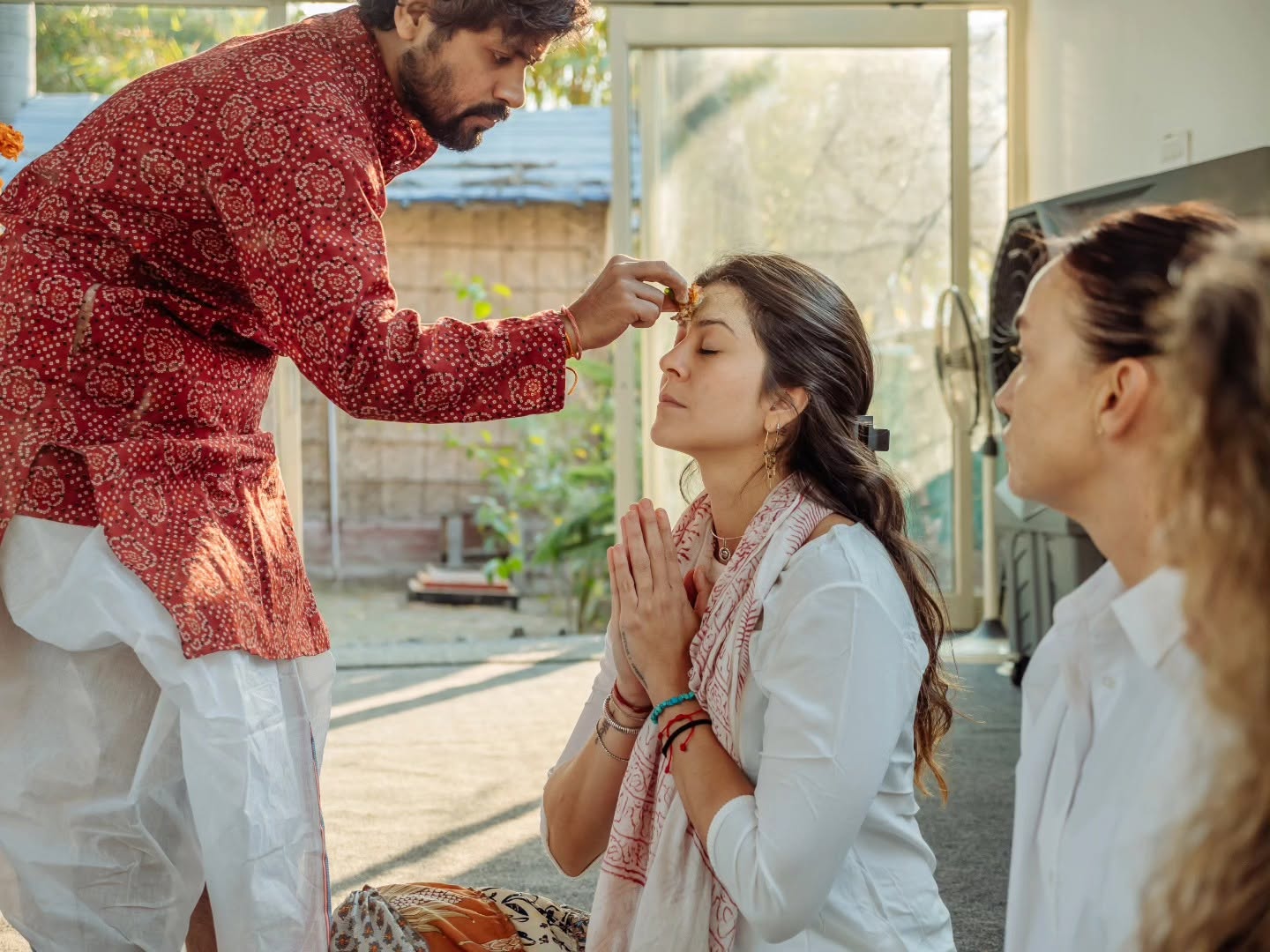 A teacher applying tilak to a student during the opening ceremony
