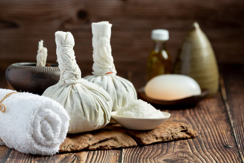 Ayurvedic herbal poultices, oil and salt laid out for a treatment