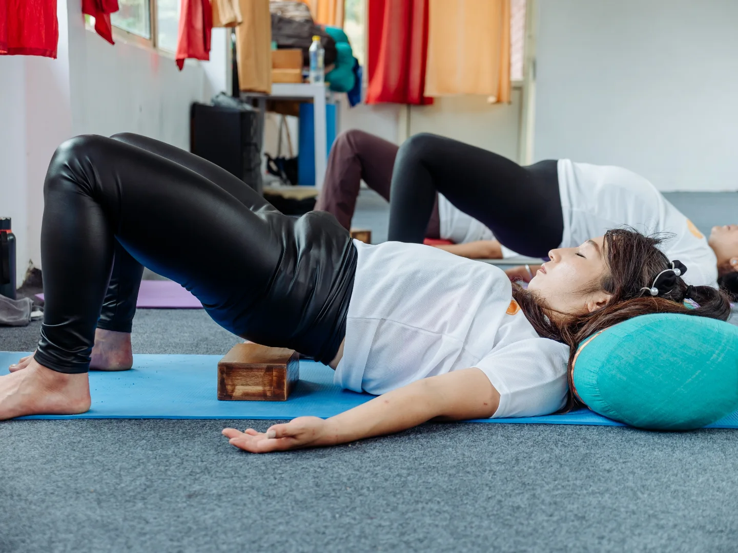 Restorative bridge pose on a block during the prenatal and postnatal yoga course