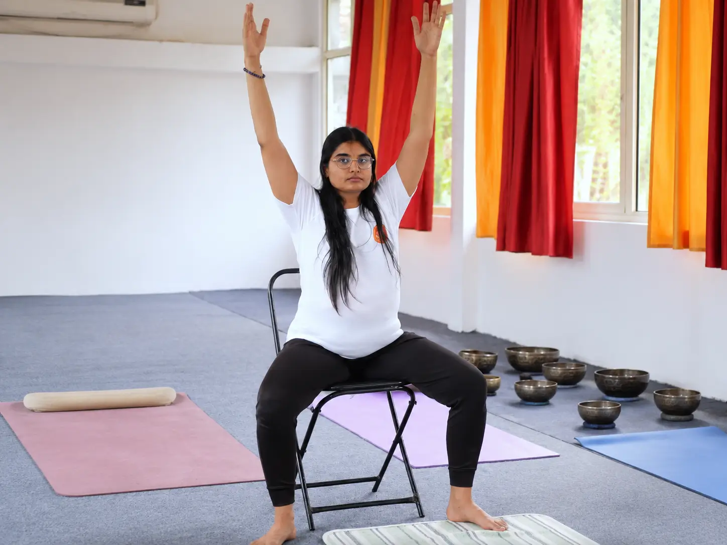 Student practising a supported chair yoga stretch one to one