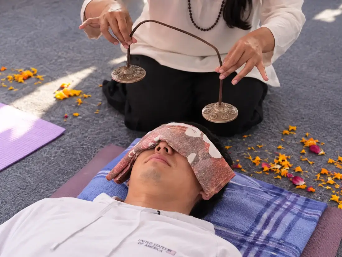 Tingsha cymbals chimed above a resting participant during a one-to-one session