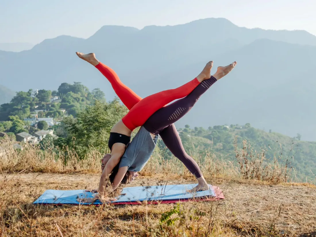 Partner yoga pose practised outdoors during the retreat