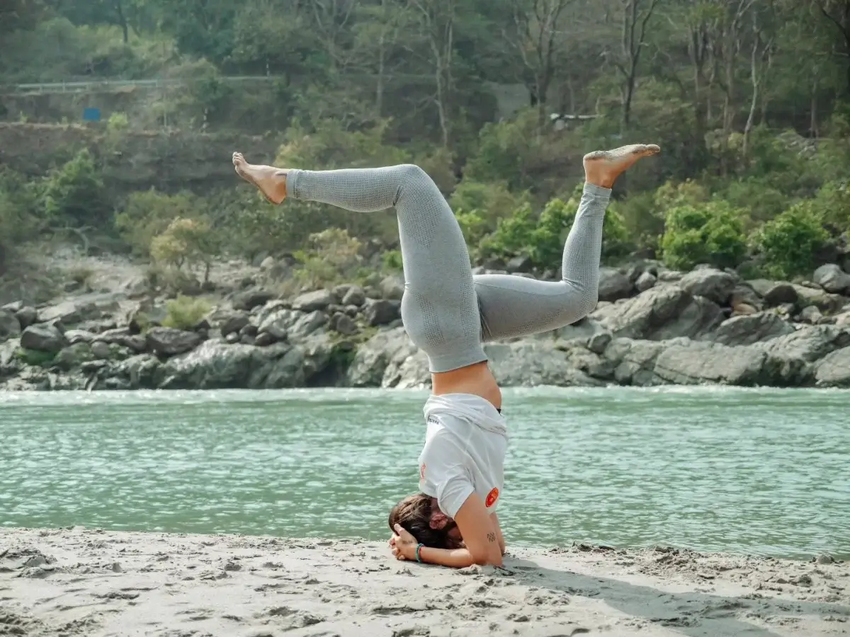 Inversion practice on the sand beside the Ganga in Rishikesh