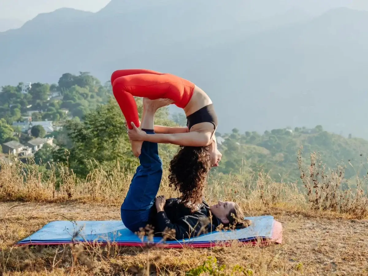 Partner practice on a hilltop above Rishikesh with the Himalayan foothills behind