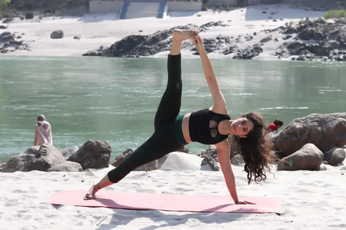Side stretch with the top leg lifted, held on the riverbank