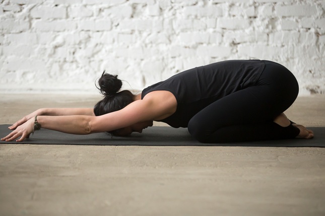Woman practicing Balasana pose during Teacher Training Course